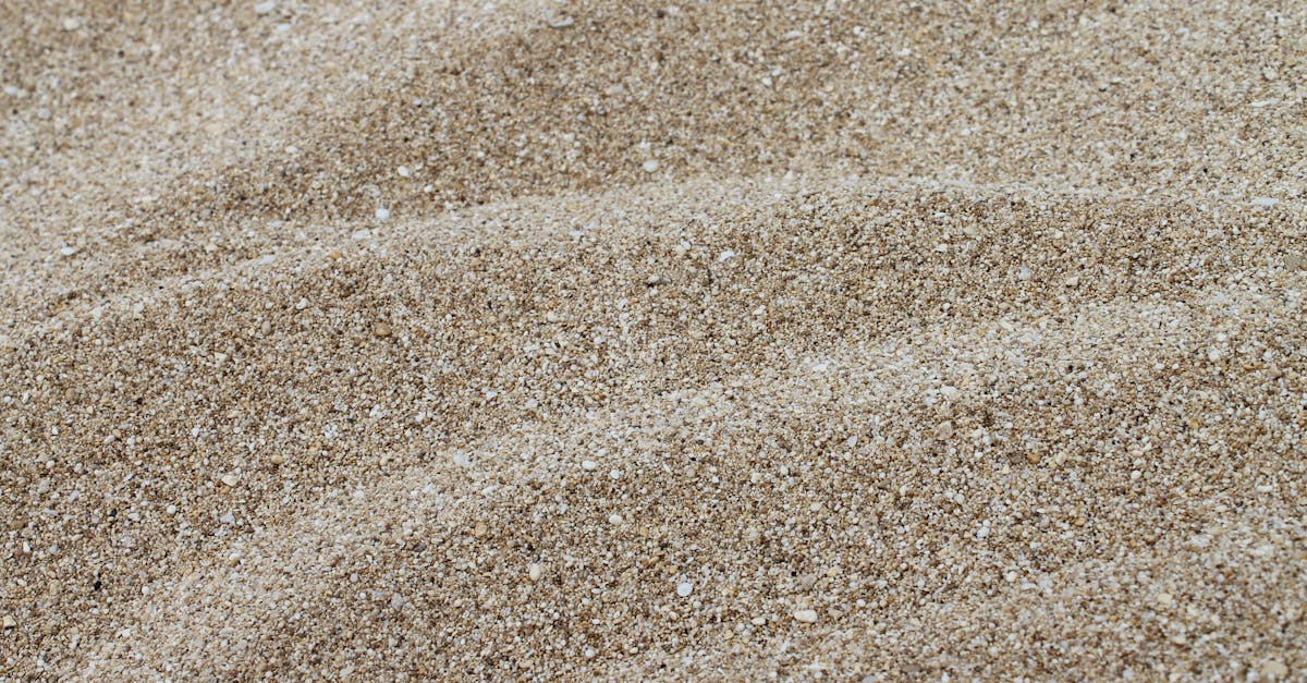 Asbestos-Contaminated Children’s Sand: RECALL! Detailed texture of fine coastal sand captured in a close-up shot.